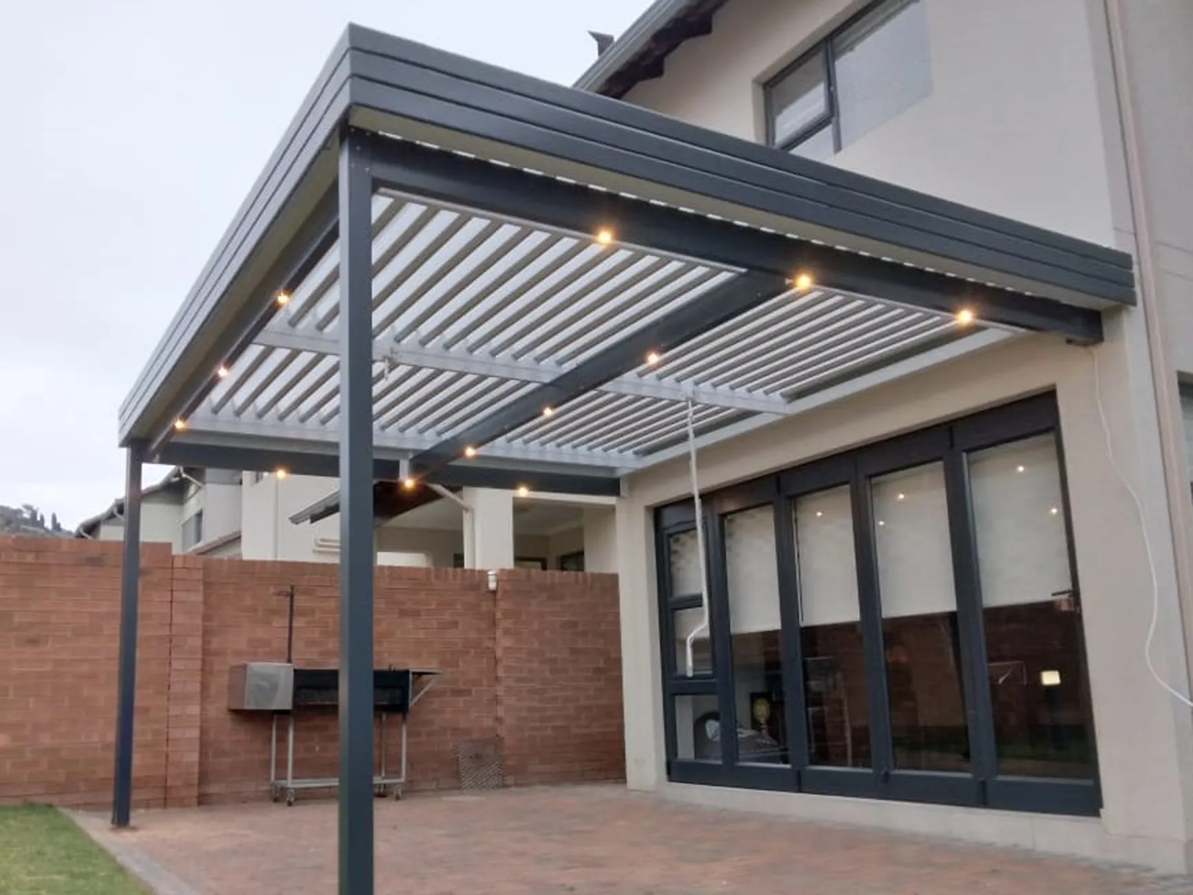 Custom adjustable aluminium louvre awning installed over a residential patio